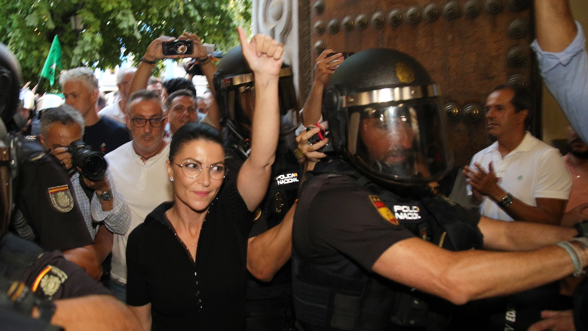 La ex política Macarena Olona (c) intenta acceder a un acto en la facultad de Derecho de Granada