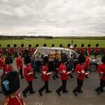 El coche fúnebre de Estado que transporta el féretro de la reina Isabel II, ataviado con el estandarte real con la corona imperial de Estado y el orbe y el cetro de la soberana, circula por Albert Road