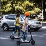 Imagen de archivo de dos chicas circulando en patinete por Madrid