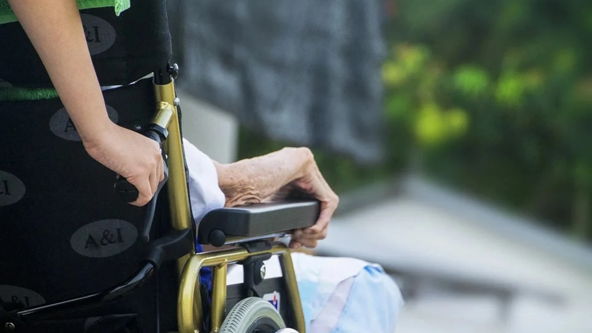 Empujan una silla de ruedas en un centro de mayores
