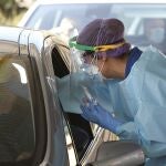 Una sanitaria realiza una prueba para detectar el coronavirus en un automóvil
