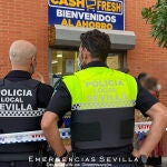 Efectivos policiales, ante la fachada del supermecado donde ha habido un atraco