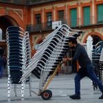 Un trabajador de la hostelería recoge la terraza de un bar