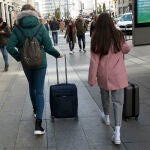 Personas con maletas buscando su reserva de piso turístico