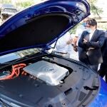 El consejero de Transportes e Infraestructuras de la Comunidad de Madrid, David Pérez, observa un vehículo propulsado con hidrógeno verde generado con energía renovable mientras visita las instalaciones de la Federación Profesional del Taxi de Madrid acompañado por el presidente de la Federación Profesional del Taxi, Julio Sanz