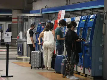 Varias personas recargan sus abonos de metro en la estación de Metro de Atocha, en Madrid Metro de Madrid ya funciona al 100%