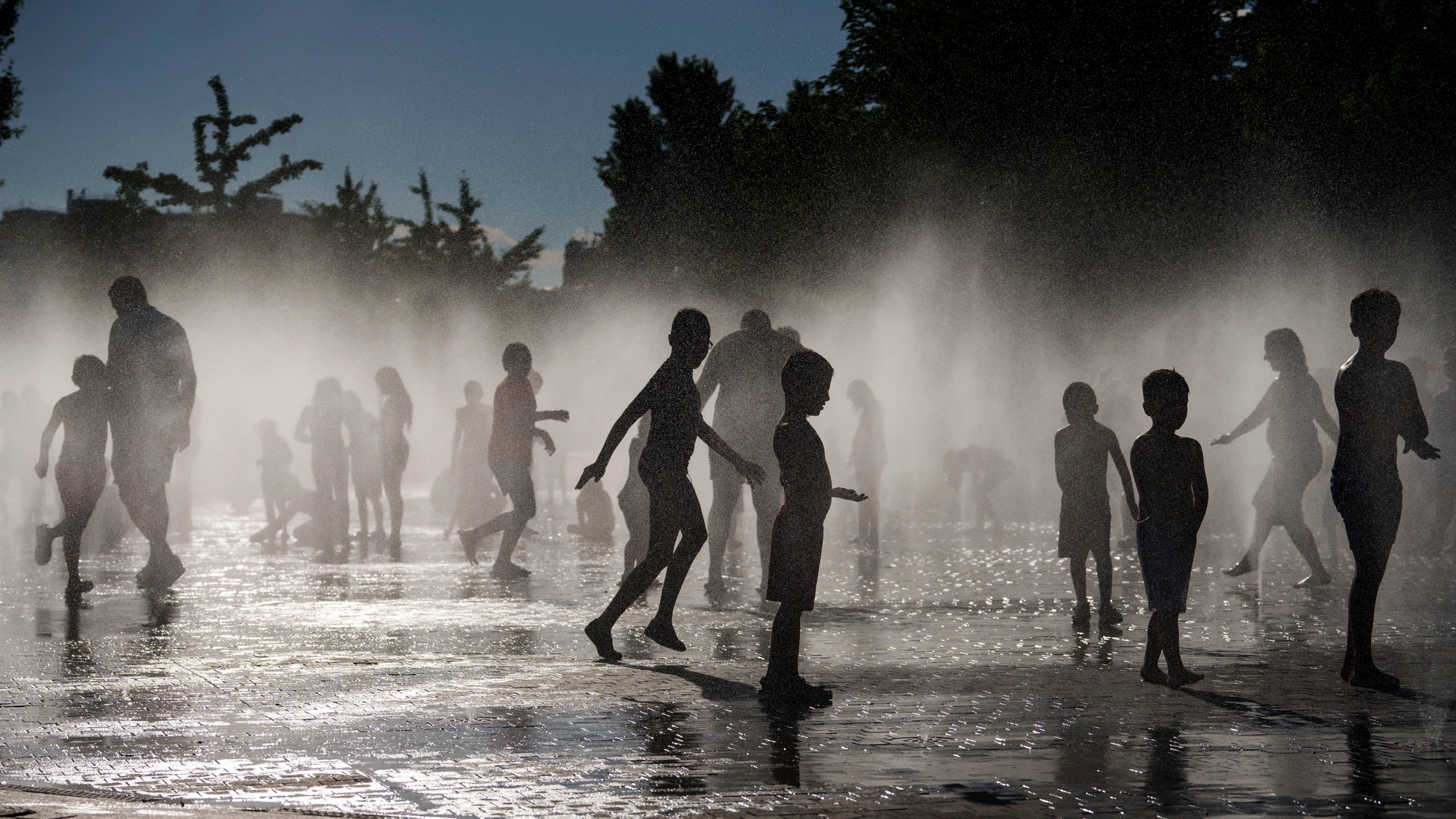 Pequeños y mayores se refrescan en Madrid este verano durante una ola de calor