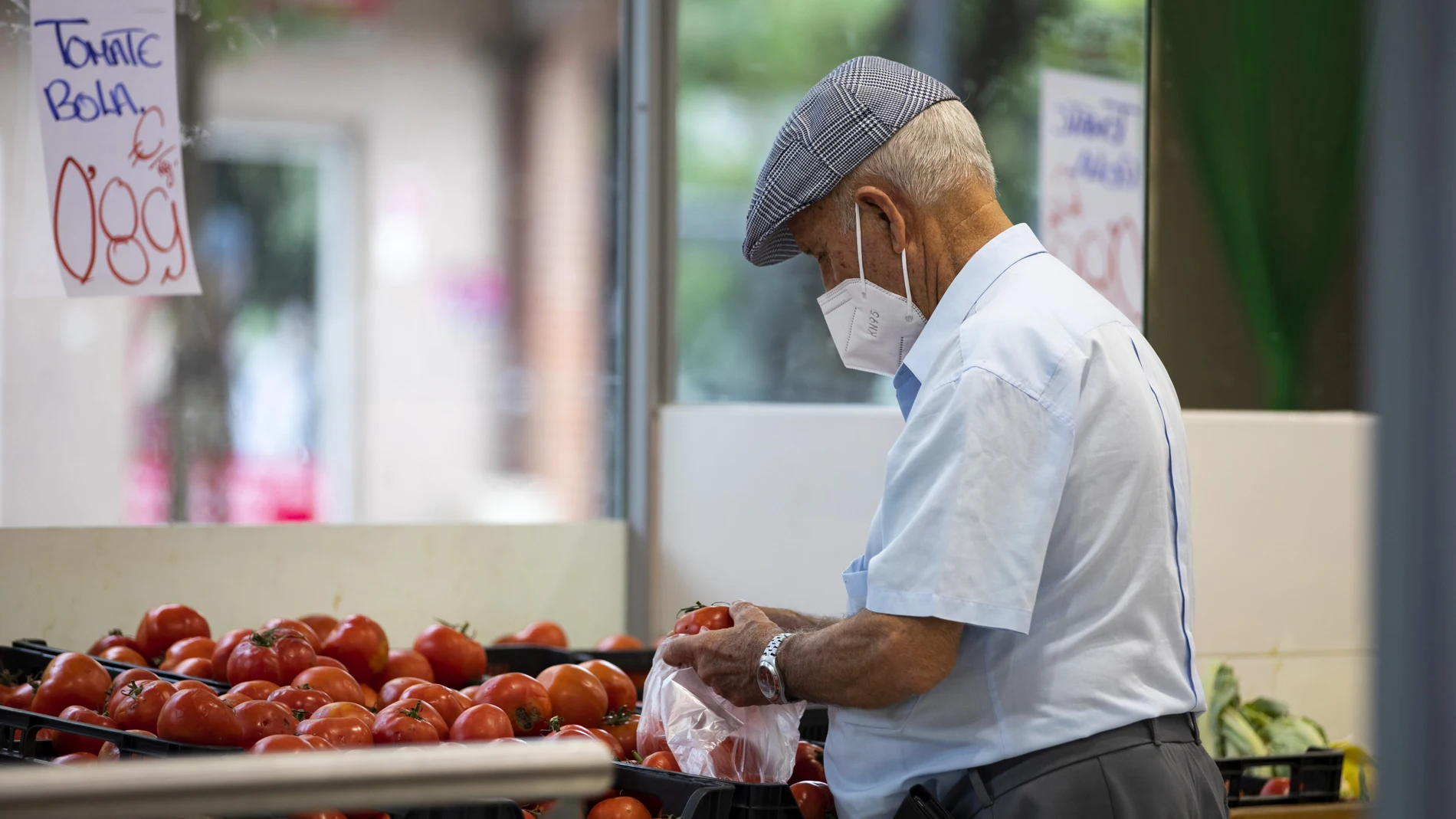 Imagen de una persona mayor comprando en una frutería