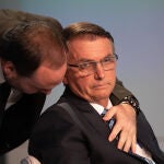 El presidente y candidato a reelección, Jair Bolsonaro (d), escucha a su hijo Carlos durante un debate hoy, con los demás candidatos, en los estudios de TV Globo en Río de Janeiro (Brasil). . EFE/André Coelho