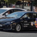 Un taxi frente a un VTC en Sevilla. EFE /Jose Manuel Vidal
