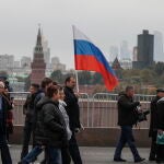 Rusos con banderas rusas se preparan para celebrar la anexión anunciada por Putin de los territorios ucranianos