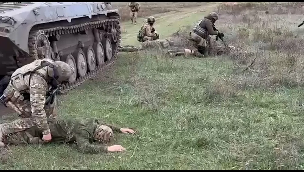 Soldados ucranianos detienen a soldados rusos que se acaban de rendir tras salir de un tanque en la región de Jersón