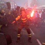 Bomberos y brigadas forestales (BRIF) simulan que apagan un fuego mientras protestan en una manifestación con el lema ‘Marea de Fuego’ para reclamar mejores derechos laborales de bomberos y brigadas forestales