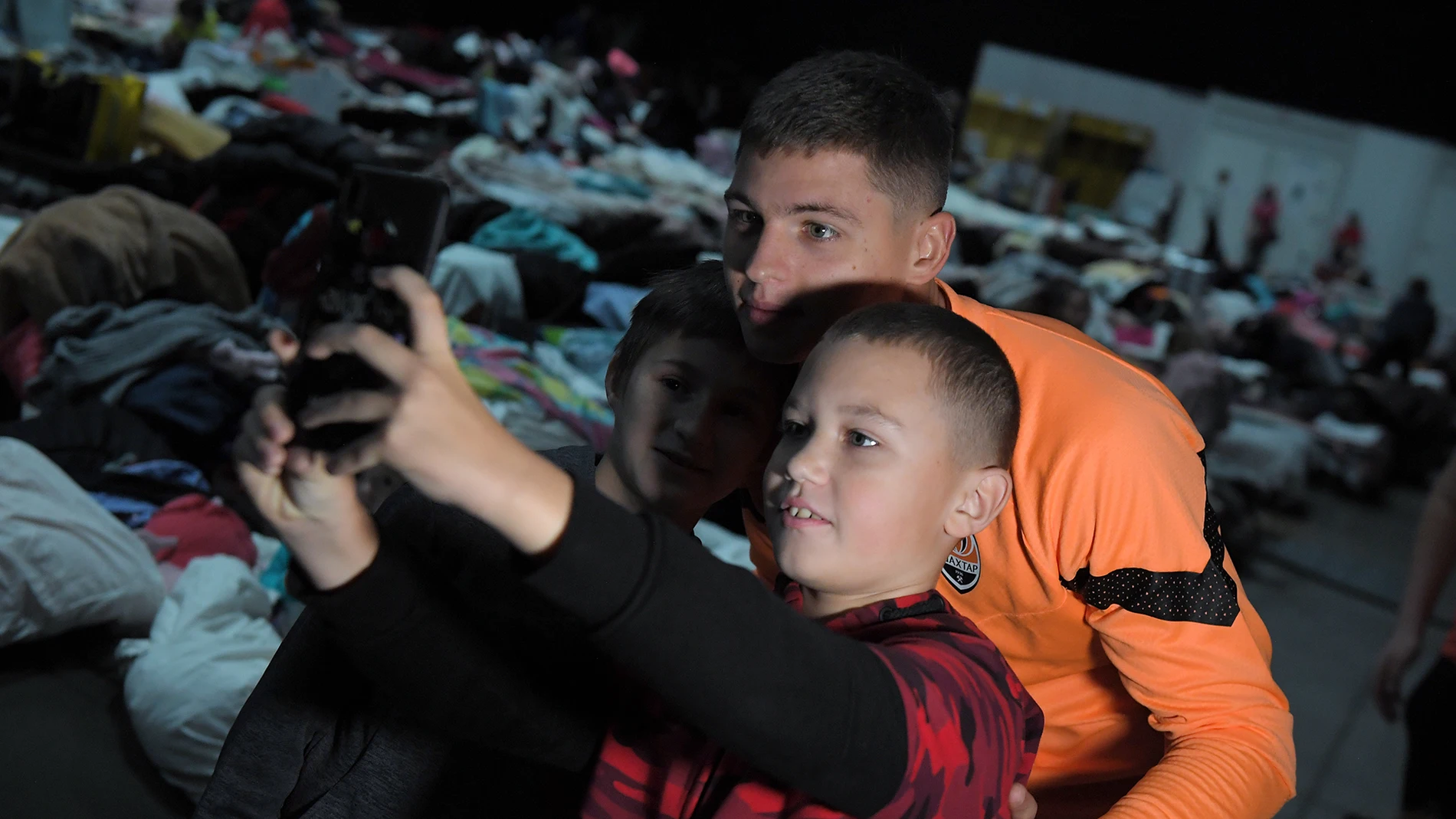 Dos niños ucranianos refugiados en Varsovia se hacen un selfie con Bondar, central del Shakhtar