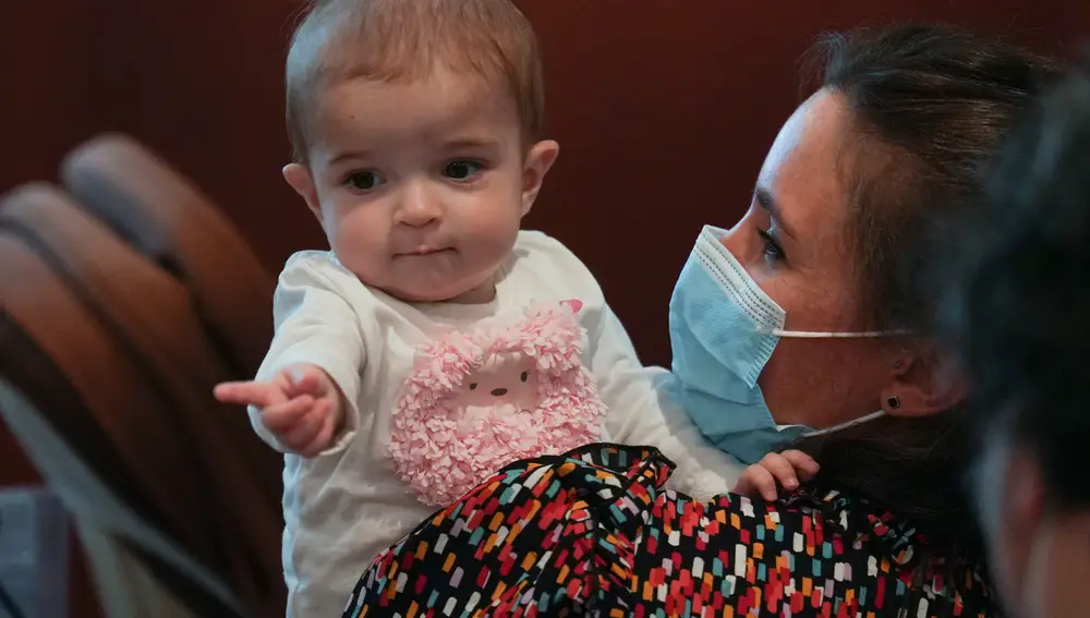 MADRID, 11/10/2022.- La pequeña Emma, de 13 meses, en brazos de su madre, Ana. El hospital público madrileño de La Paz ha realizado con éxito por primera vez en el mundo un trasplante multivisceral de intestino procedente de una donación en asistolia controlada pediátrica a la niña de 13 meses que fue dada de alta y se encuentra en perfecto estado de salud en su domicilio. EFE/ Borja Sánchez-Trillo