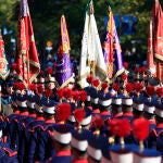 Numerosas banderas de distintas unidades militares muestran la cruz de Borgoña durante el desfile del 12 de octubre hoy en Madrid