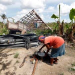 Una mujer cocina sus alimentos con leña, fuera de su casa, tras el paso del huracán Ian, el 14 de octubre en Cuba
