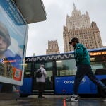 Un hombre pasa junto a un cartel propagandístico que dice «Gloria a los héroes de Rusia» con soldados en el frente