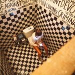 Chica orinando en un baño público