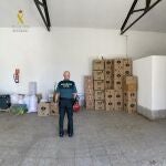 Un agente de la Guardia Civil en la nave usada para almacenar y fabricar tabaco de manera clandestina en Villaverde del Río, en Sevilla. GUARDIA CIVIL SEVILLA
