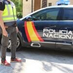Un agente junto a un vehículo de la Policía Nacional