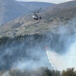Un helicóptero trata de apagar el incendio forestal en Arenas de Iguña