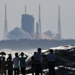 In this photo released by Xinhua News Agency, people watch the Long March-5B Y4 carrier rocket carrying the space lab module Mengtian, blasts off from the Wenchang Satellite Launch Center in south China's Hainan Province, Monday, Oct. 31, 2022. China has launched the third and final module to complete its permanent space station, realizing a more than decade-long endeavor to maintain a constant crewed presence in orbit. (Yang Guanyu/Xinhua via AP)