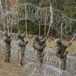 Soldados polacos instalan este miércoles alambre de espino a lo largo de la frontera polaca con el exclave ruso de Kaliningrado, cerca del pueblo de Zerdziny