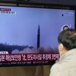 Una pantalla de televisión que muestra un programa de noticias que informa sobre el lanzamiento de misiles de Corea del Norte con imágenes de archivo se ve en la estación de tren de Seúl