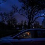 Una mujer se sienta en un coche después de que las luces se apagaran debido a los cortes de energía programados que se introdujeron en Kyiv