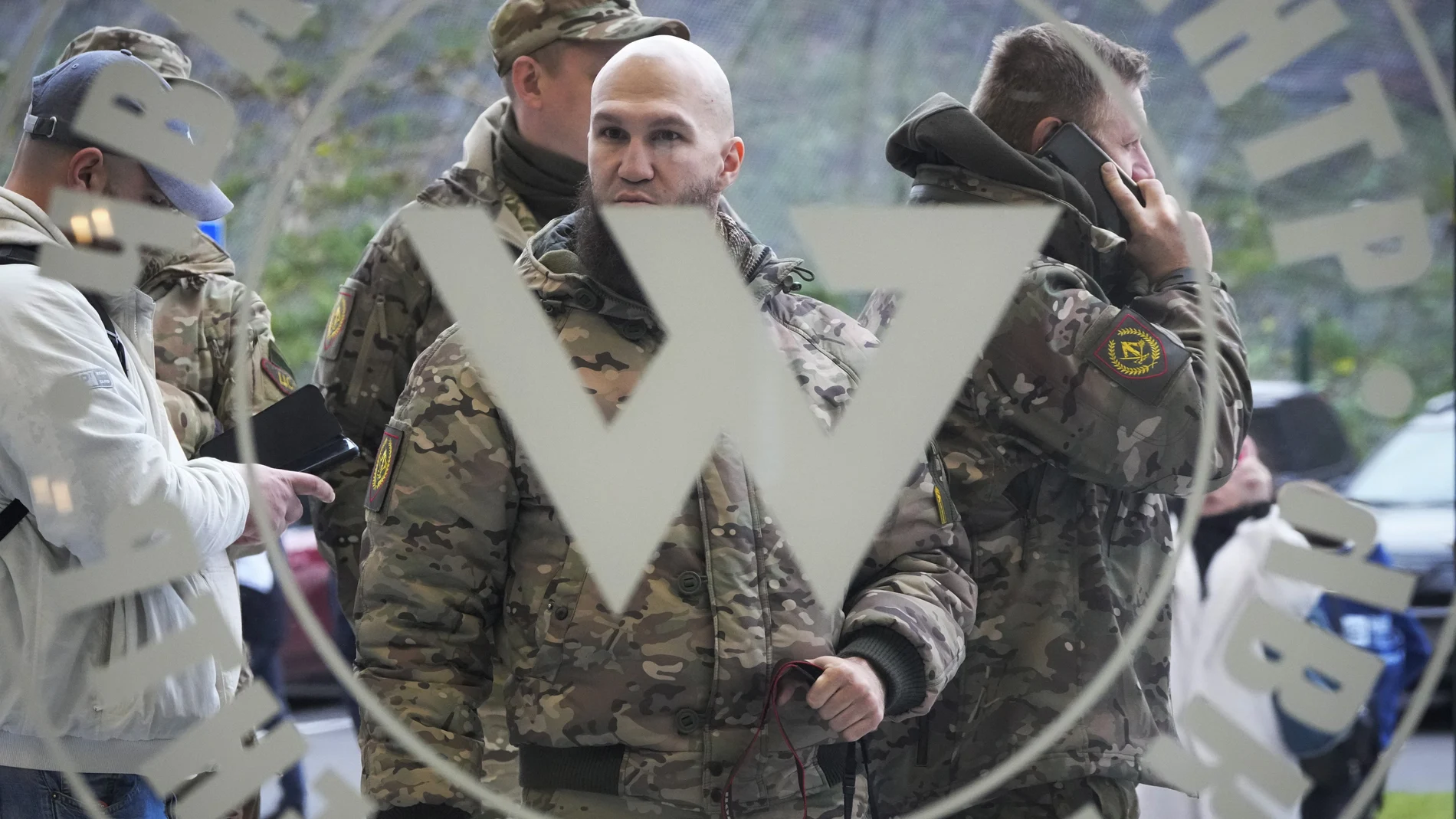 Visitantes vestidos con camuflaje militar frente a la entrada principal del Centro Wagner en San Petersburgo, Rusia