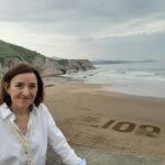 Laia Alegret junto al logo de los 100 Primeros Lugares del Patrimonio Geológico de la Unión Internacional de Ciencias Geológicas, en Zumaia