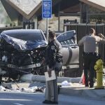 Dos agentes se detienen junto a un vehículo SUV destrozado que golpeó a los reclutas del alguacil del condado de Los Ángeles en Whittier