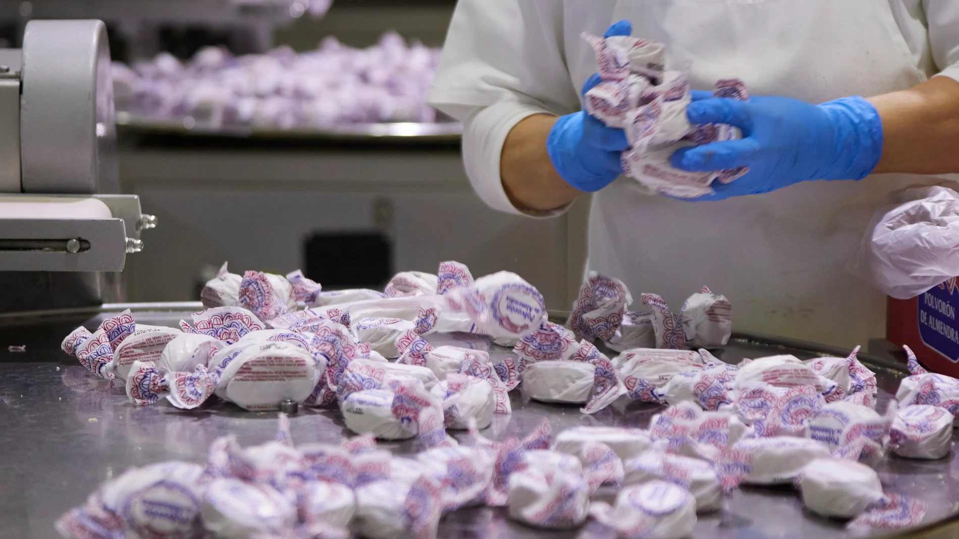 Una operaria manipulando polvorones de almendra
