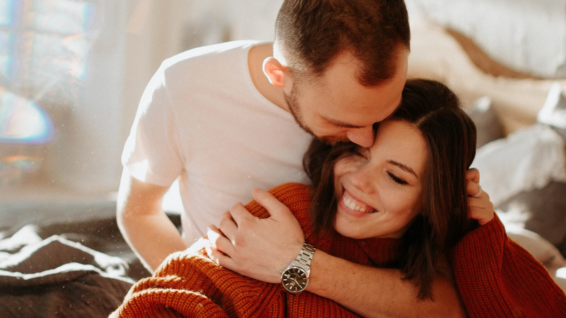 Pareja abrazándose en la cama
