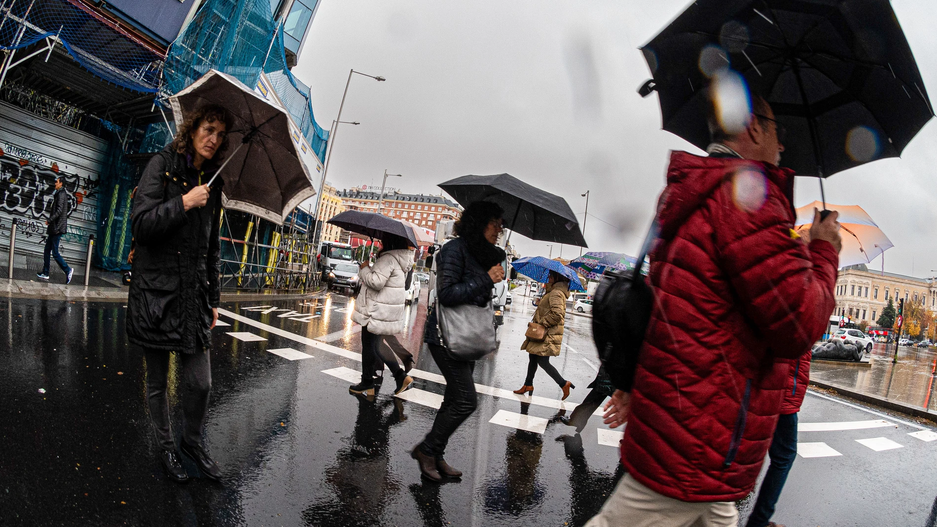 Varias personas se protegen de la lluvia