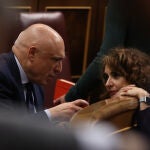 La ministra de Hacienda y Función Pública, María Jesús Montero (d), conversa con el diputado socialista Rafael Simancas (i) durante el pleno que se celebra este martes en el Congreso