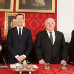 El presidente de la Junta de Andalucía, Juanma Moreno (c), junto al presidente del Parlamento de Andalucía, Jesús Aguirre (d) y al presidente de la Real Academia Sevillana de Buenas Letras, Pablo Gutiérrez Alviz, durante el acto de homenaje a Manuel Clavero. EFE/José Manuel Vidal
