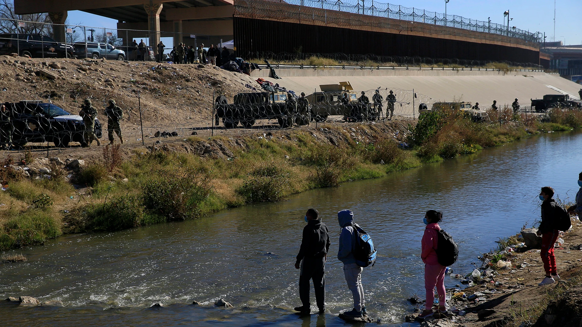 Migrantes caminan en una orilla del Río Bravo ante el operativo implementado por la Guardia Nacional de EE UU en la frontera con Ciudad Juárez, Chihuahua (México)