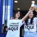 Dos personas celebrando un premio en una administración
