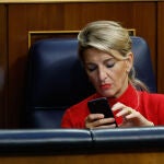 La vicepresidenta segunda y ministra de Trabajo, Yolanda Díaz, revisa su teléfono durante el pleno celebrado en el Congreso de los Diputados