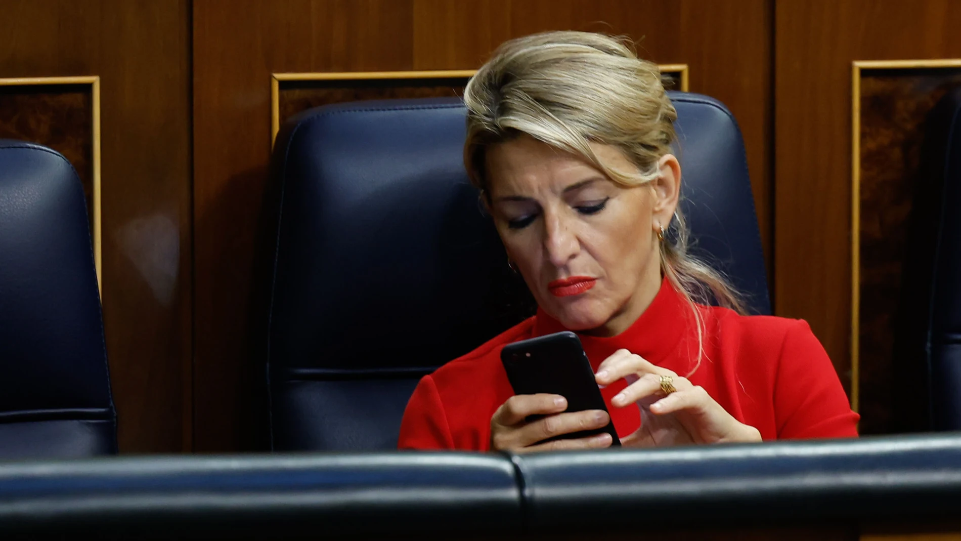 La vicepresidenta segunda y ministra de Trabajo, Yolanda Díaz, revisa su teléfono durante el pleno celebrado en el Congreso de los Diputados