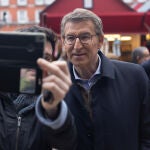 Alberto Núñez Feijóo se hace una foto con un simpatizante durante un paseo por la Plaza Mayor de Madrid, a 23 de diciembre