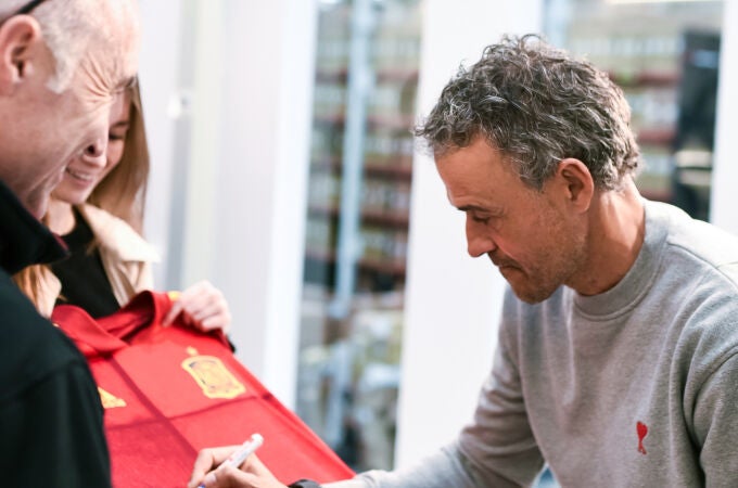 Luis Enrique firma una camiseta de la selección durante su visita a la fábrica de MMR