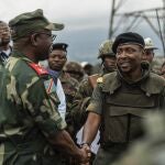 Willy Ngoma, portavoz del M23, estrecha la mano del comandante de la Fuerza Regional de la CAO tras la retirada de la guerrilla de Kibumba, este 23 de diciembre.