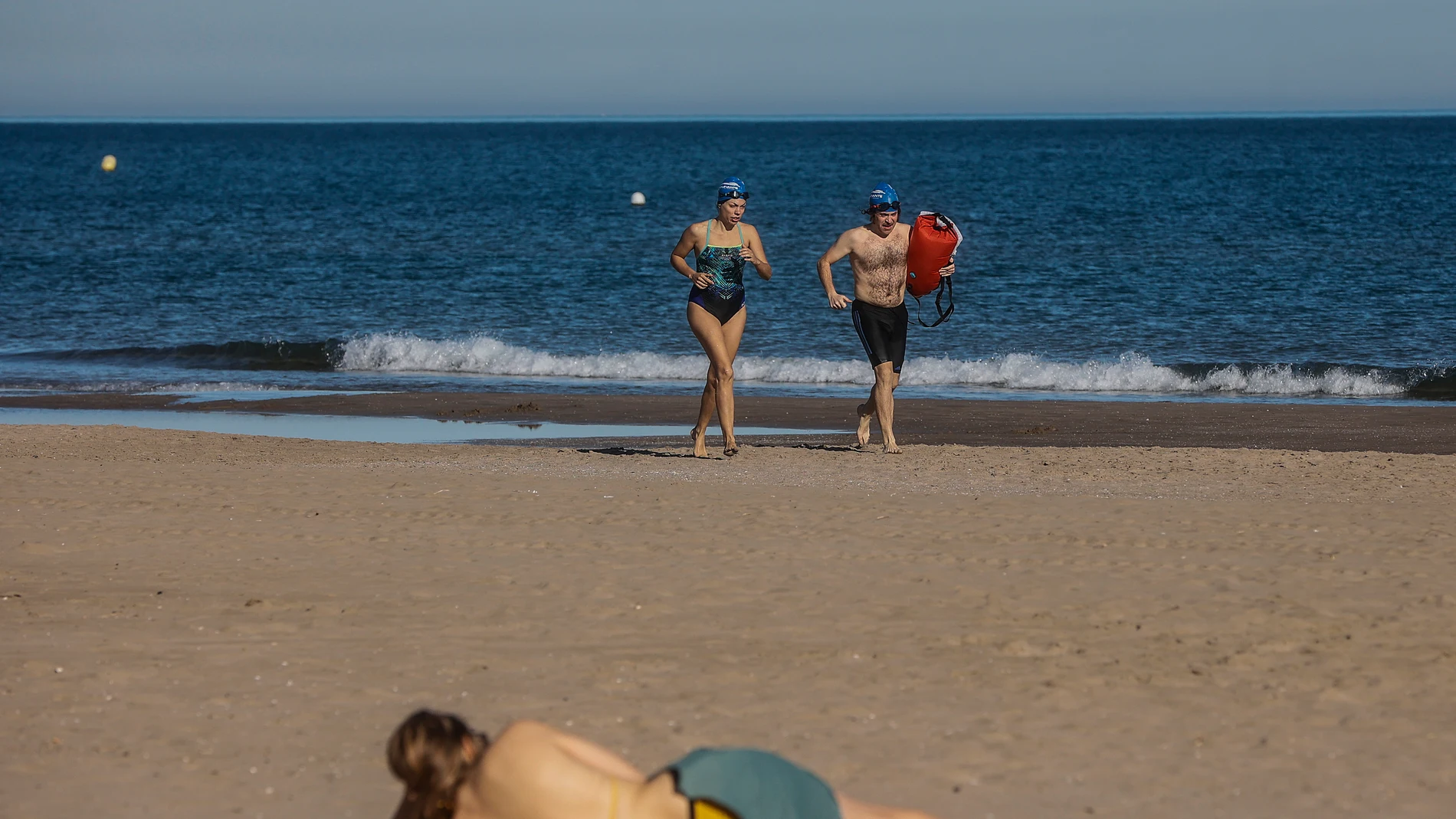 Dos personas haciendo footing en la playa