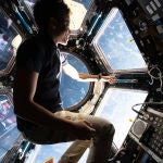 La astronauta de la NASA e ingeniera de vuelo de la Expedición 67 Jessica Watkins disfruta de la vista de la Tierra desde el interior de la cúpula de siete ventanas de la Estación Espacial Internacional. (Fotografía de la NASA editada por Mark García)