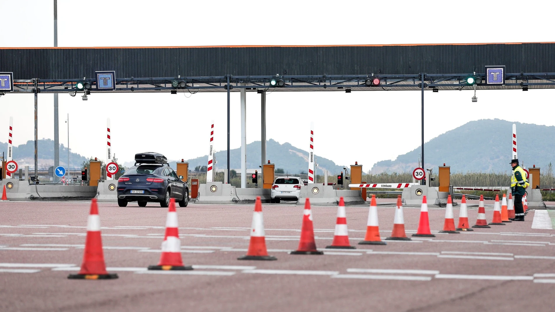 Varios vehículos ser acercan al área de peaje de una autopista de pago