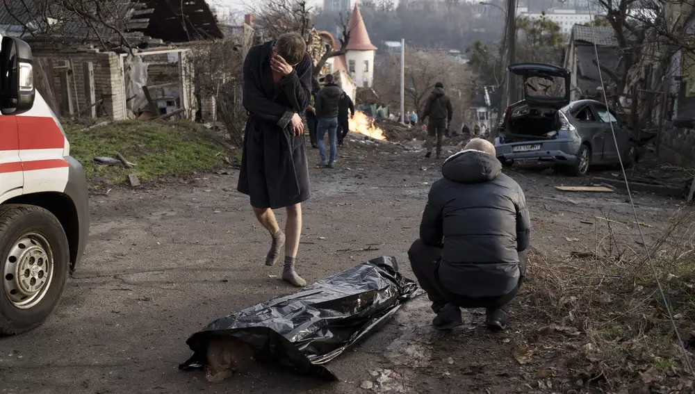Un hombre junto al cuerpo de su mujer tras un ataque ruso en Kiev