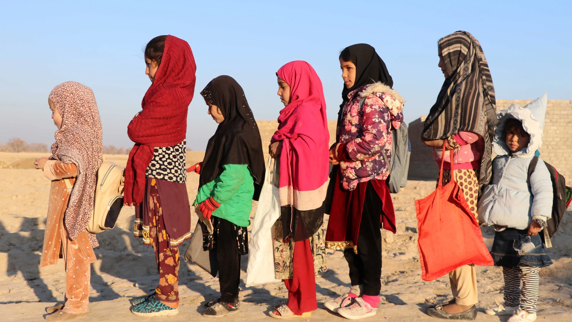 Niñas afganas llegan para asistir a la última clase en un centro educativo antes de su cierre tras la prohibición de los talibanes de que las mujeres trabajen en ONG, en el distrito de Dand de Kandahar, Afganistán, el 1 de enero